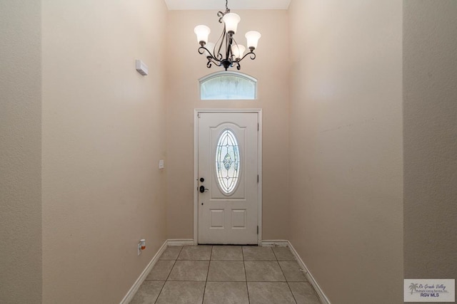 doorway to outside with light tile patterned flooring and a chandelier