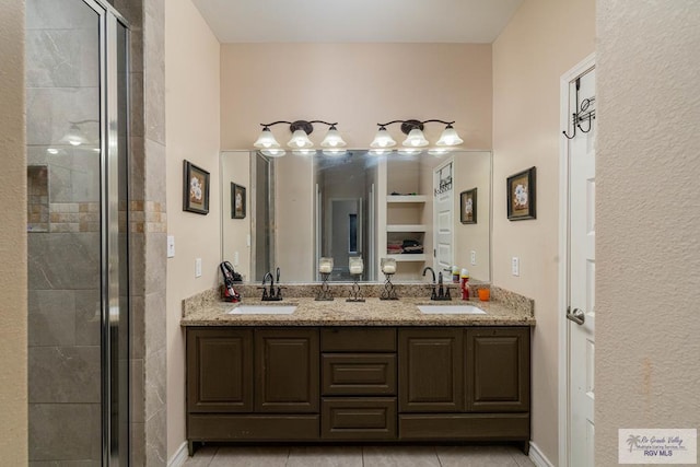 bathroom featuring tile patterned flooring, vanity, and a shower with shower door