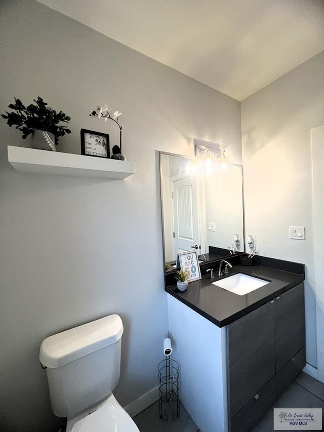 bathroom featuring tile patterned flooring, vanity, and toilet