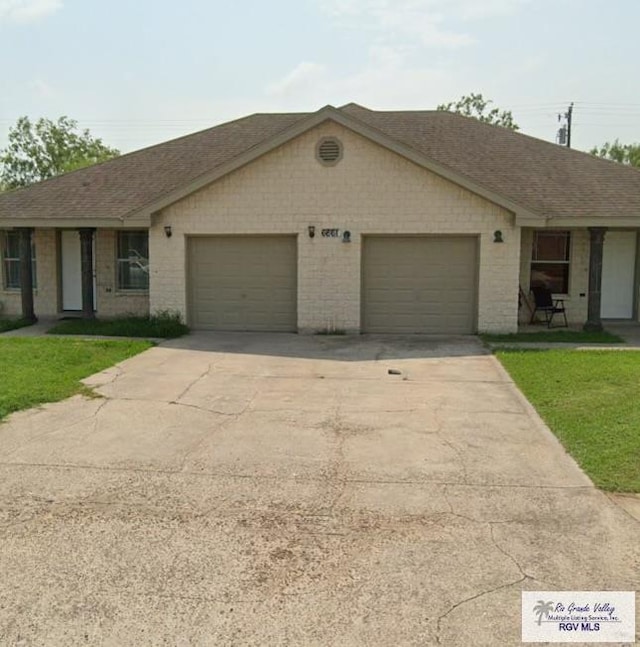 ranch-style house with a shingled roof, concrete driveway, brick siding, a front yard, and a garage