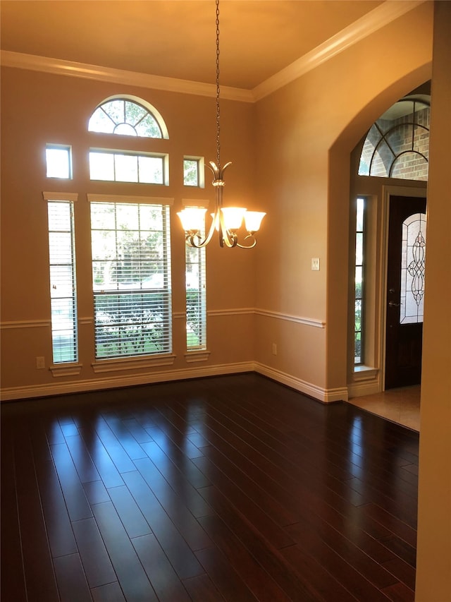 foyer featuring crown molding, dark wood-type flooring, and a notable chandelier