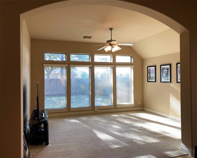 unfurnished living room featuring ceiling fan, light colored carpet, and vaulted ceiling