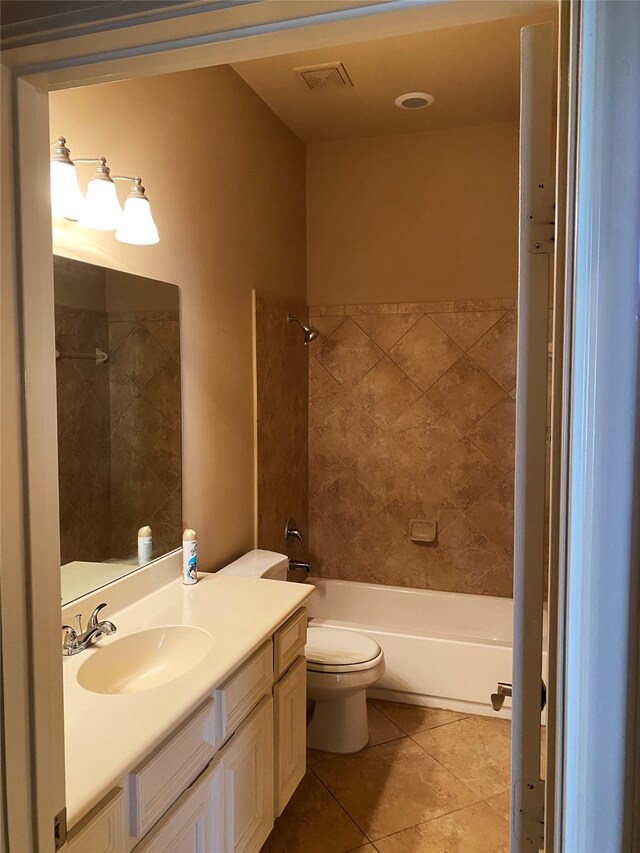 full bathroom featuring tile patterned floors, tiled shower / bath combo, vanity, and toilet