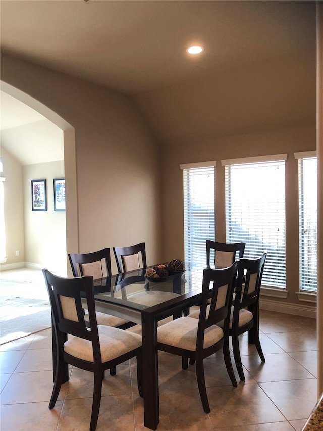 tiled dining room with lofted ceiling