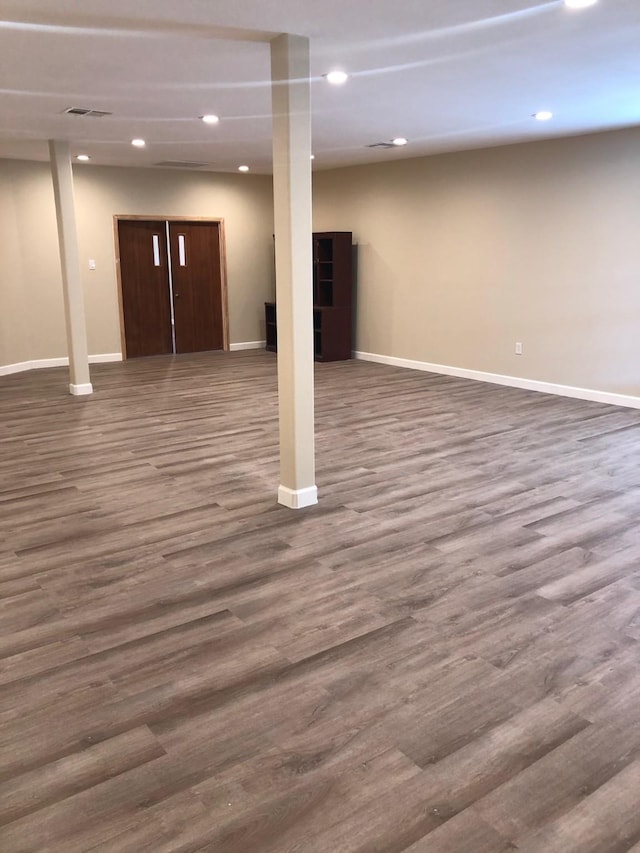 basement with dark hardwood / wood-style floors