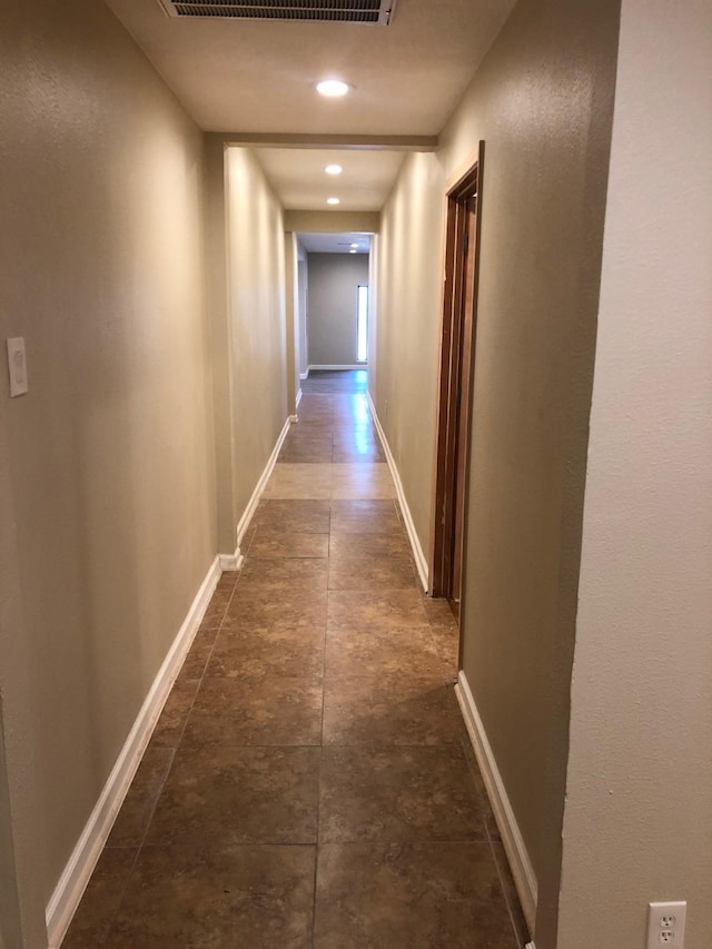 corridor featuring dark tile flooring