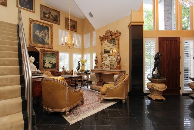 living area featuring dark tile patterned floors, high vaulted ceiling, and an inviting chandelier