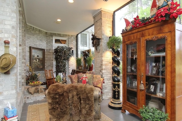 interior space with light tile patterned floors, crown molding, and brick wall