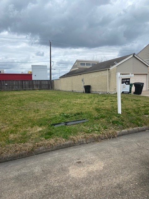 view of side of home featuring a lawn and a garage