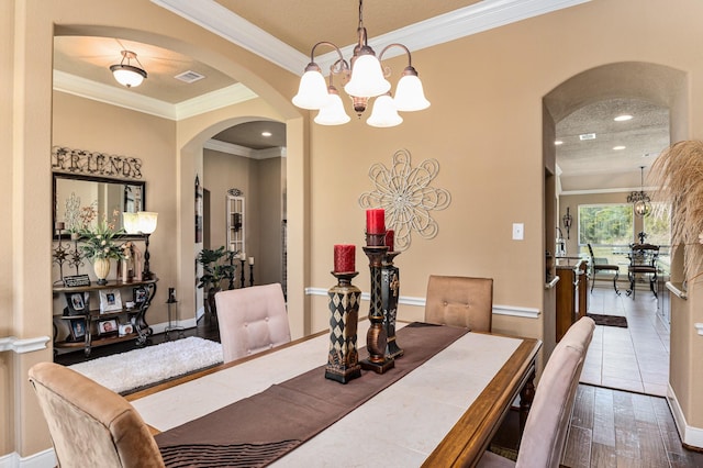 dining room with crown molding, a textured ceiling, tile floors, and a chandelier