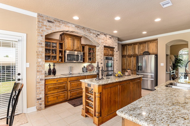 kitchen with stainless steel appliances, a center island, and light tile floors