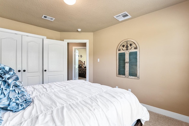 bedroom with light carpet, a textured ceiling, and a closet