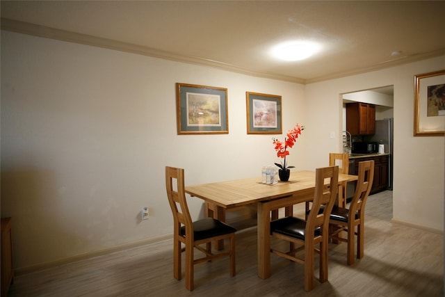 dining space featuring ornamental molding and wood-type flooring