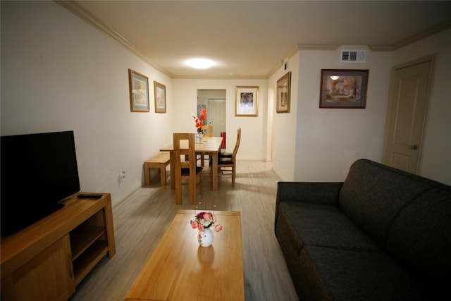 living room featuring crown molding and light wood-type flooring