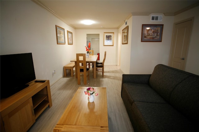 living room with ornamental molding and light hardwood / wood-style floors