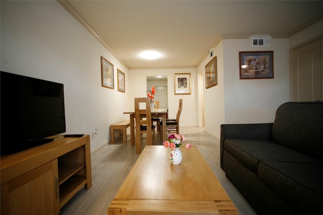 living room featuring crown molding and light hardwood / wood-style floors