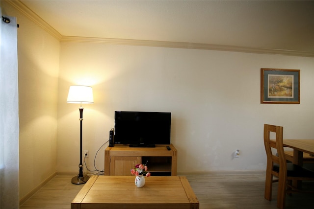 living room with ornamental molding and light hardwood / wood-style floors