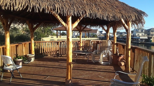 wooden terrace featuring a gazebo and a water view