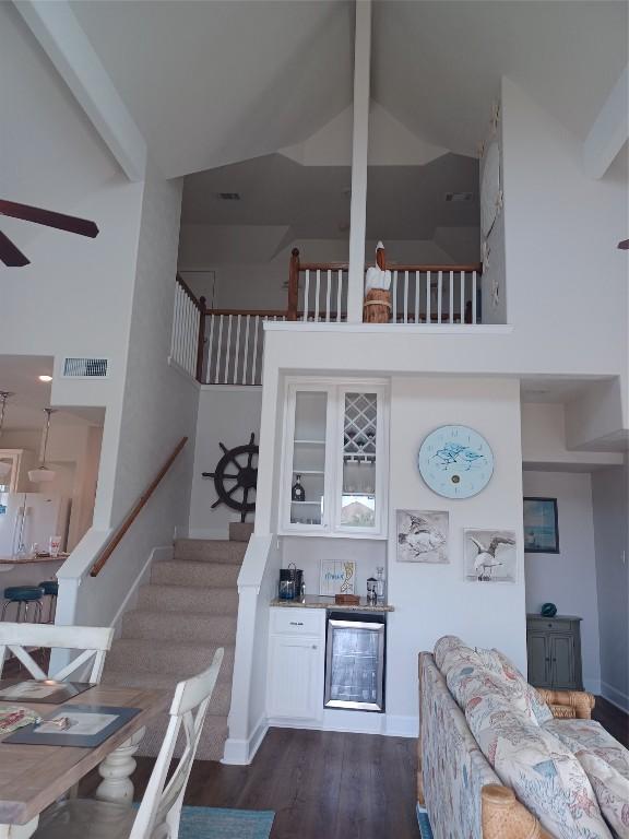 stairway featuring high vaulted ceiling, ceiling fan, and dark hardwood / wood-style floors