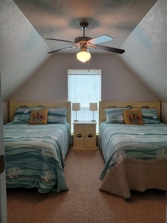 bedroom featuring light carpet, vaulted ceiling, and ceiling fan