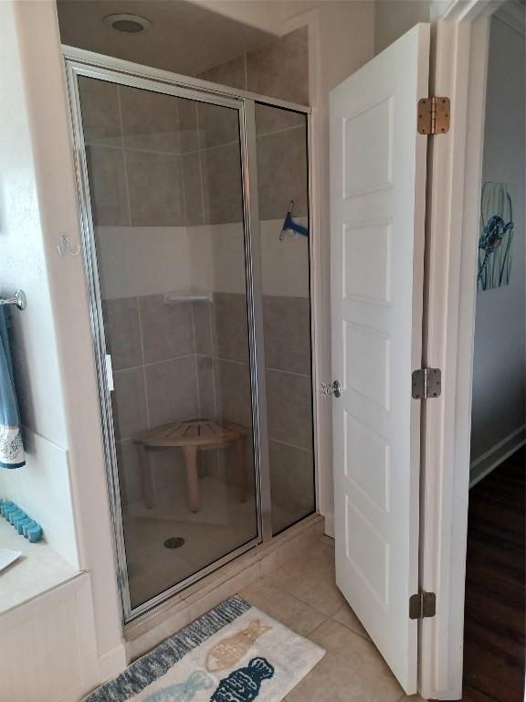 bathroom with hardwood / wood-style floors and an enclosed shower