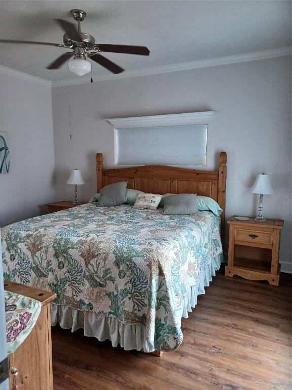 bedroom with crown molding, ceiling fan, and hardwood / wood-style flooring