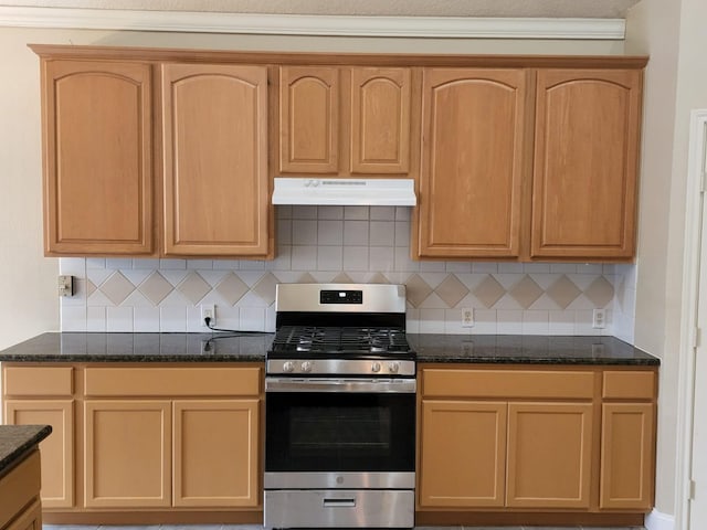 kitchen featuring gas stove, dark stone countertops, and tasteful backsplash