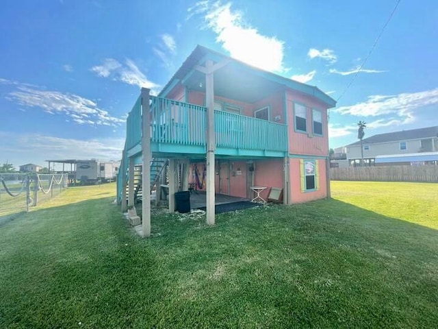 rear view of property featuring a deck and a yard