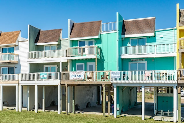 rear view of property with a balcony, a yard, and a patio