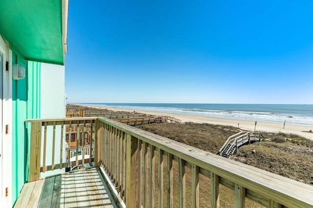 balcony with a water view and a view of the beach