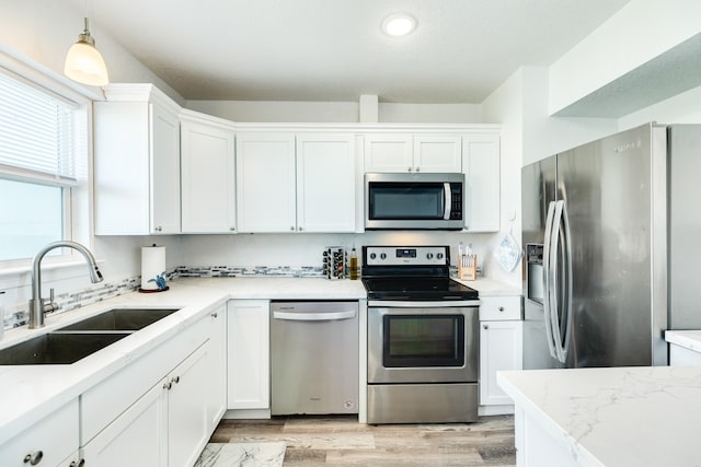 kitchen featuring white cabinetry, light hardwood / wood-style floors, appliances with stainless steel finishes, and sink