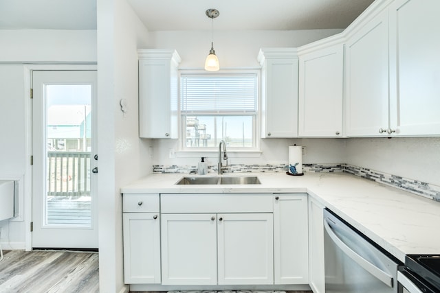 kitchen with white cabinets, light hardwood / wood-style flooring, sink, and hanging light fixtures