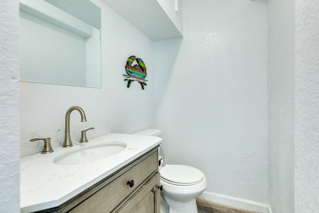 bathroom with hardwood / wood-style floors, toilet, and large vanity