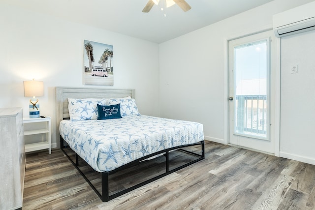 bedroom with a wall mounted air conditioner, ceiling fan, and light wood-type flooring