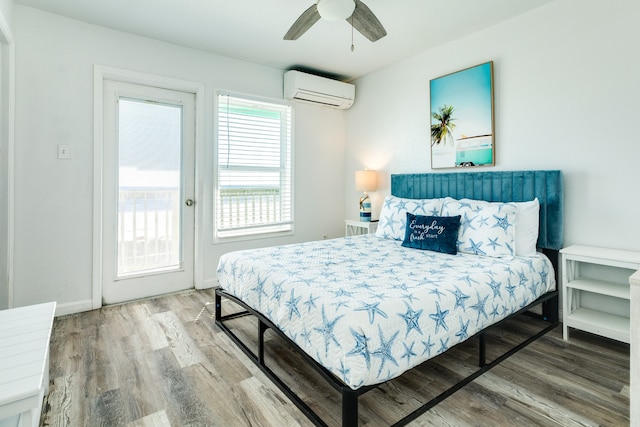 bedroom with access to outside, wood-type flooring, ceiling fan, and a wall mounted AC