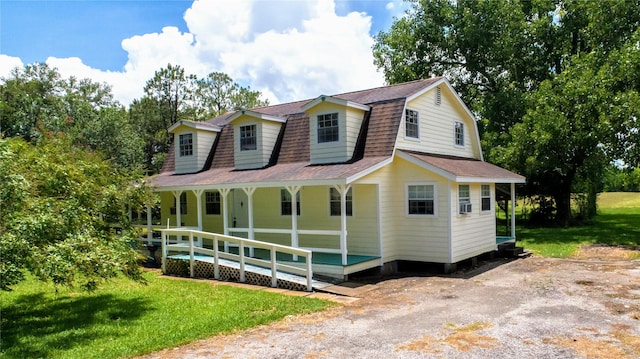 cape cod-style house featuring a porch and a front lawn