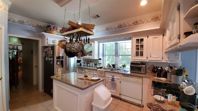 kitchen with light stone counters, white cabinetry, crown molding, light tile flooring, and white dishwasher