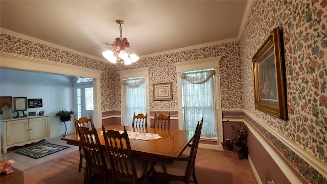 carpeted dining space featuring ornamental molding and an inviting chandelier