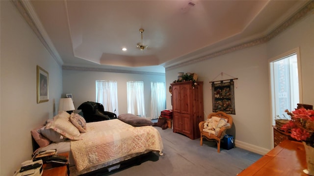 bedroom with crown molding, light colored carpet, and a tray ceiling