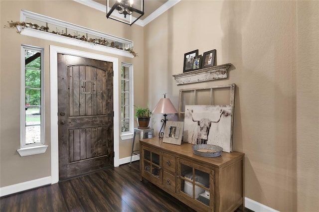 entrance foyer with a chandelier, ornamental molding, and dark wood-type flooring