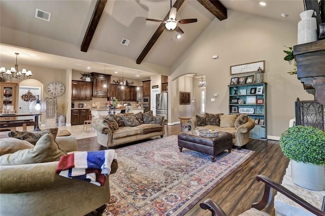 living room featuring beam ceiling, dark wood-type flooring, high vaulted ceiling, and ceiling fan with notable chandelier