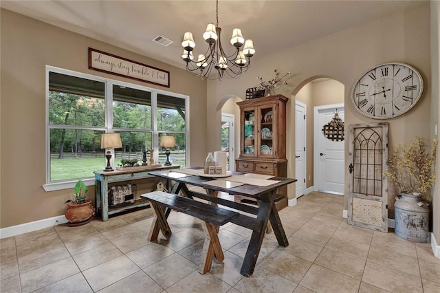 dining area featuring light tile floors, a notable chandelier, and a wealth of natural light