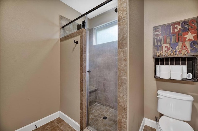 bathroom featuring toilet, tile flooring, and a shower with door