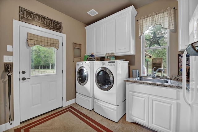 washroom featuring cabinets, a healthy amount of sunlight, sink, and washer and clothes dryer