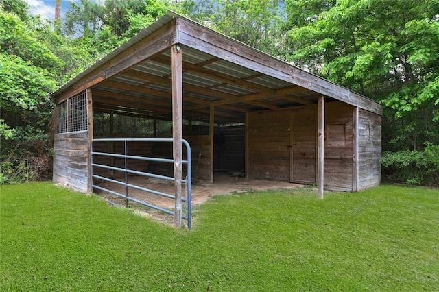 view of horse barn featuring an outdoor structure and a yard