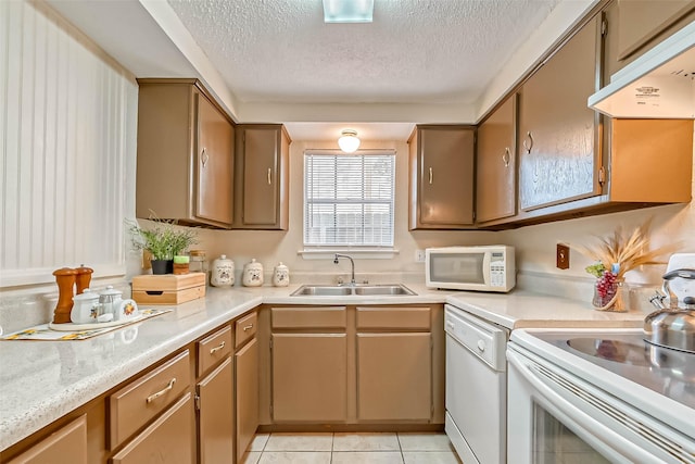 kitchen featuring sink, white appliances, a textured ceiling, and light tile patterned flooring