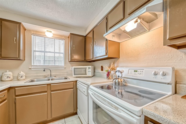 kitchen featuring range hood, light tile patterned flooring, sink, white appliances, and a textured ceiling