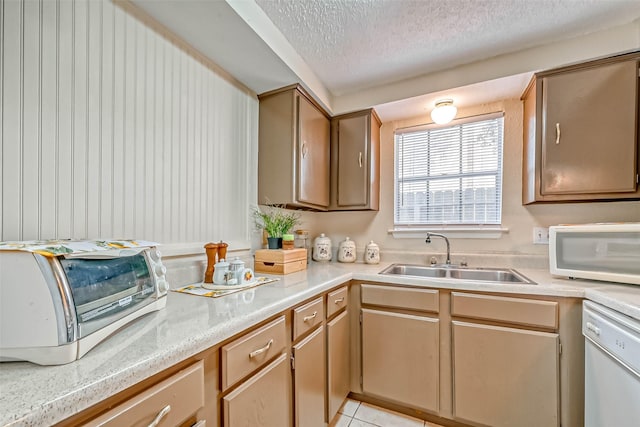 kitchen with a textured ceiling, white appliances, light tile patterned flooring, and sink