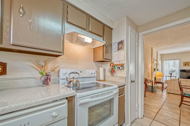 kitchen with white appliances, a textured ceiling, and light tile patterned flooring