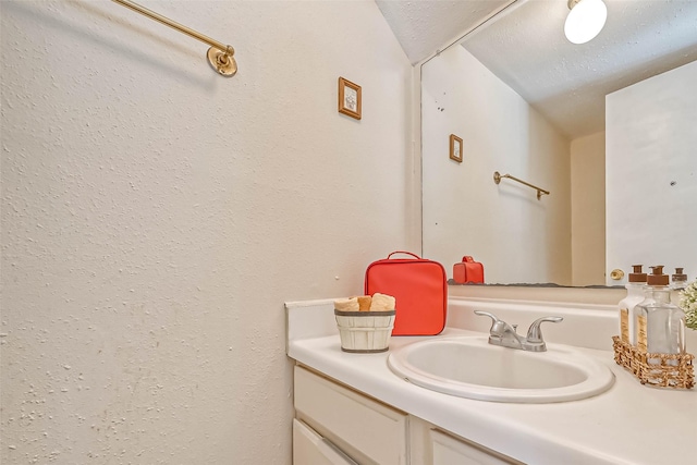 bathroom featuring a textured ceiling and vanity